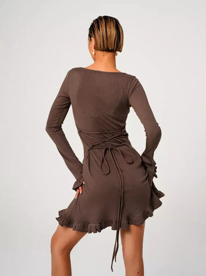 Back view of a Mocha Flare mini dress featuring ribbed knit fabric, flared cuffs, and ruffled hem, perfect for summer occasions.