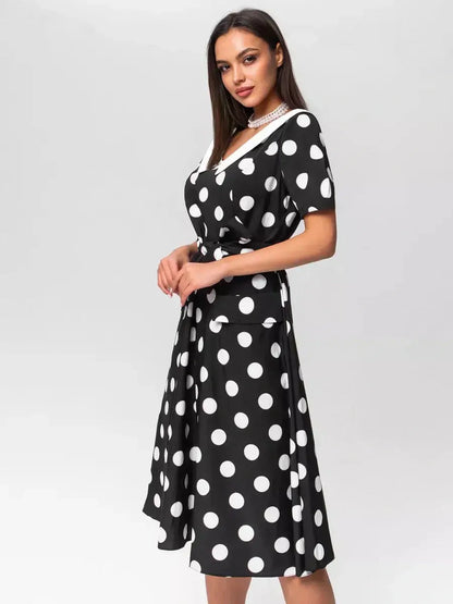 Elegant black-and-white polka dot midi dress with V-neckline and waist tie, perfect for summer occasions.