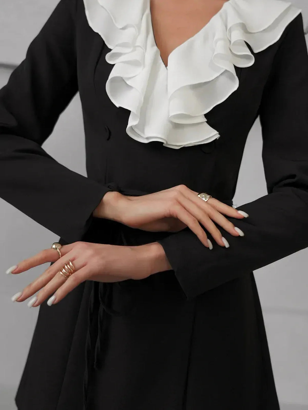 Elegant black mini dress with bold white ruffle collar, perfect for weddings, parties, and upscale occasions.