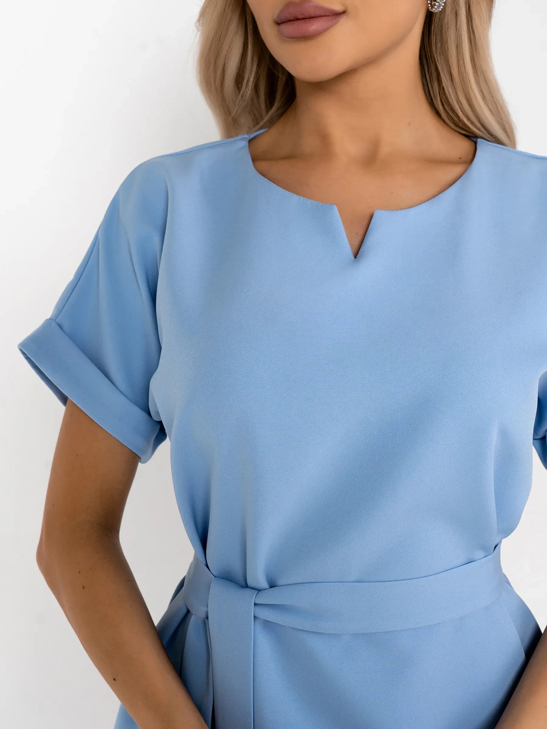 Close-up of a light blue mini dress featuring a relaxed sheath silhouette and a subtle V-notch neckline.