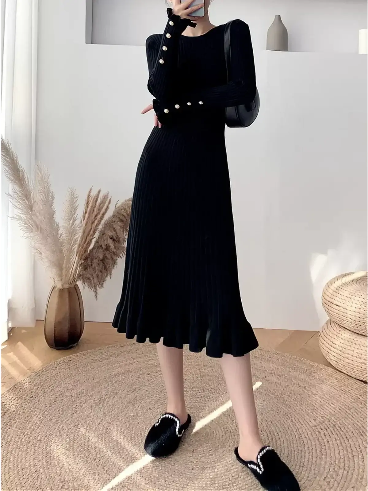 Elegant black Sculpted Pearl Midi Dress featuring pearl button cuffs and a ruffled hem, perfect for special occasions.