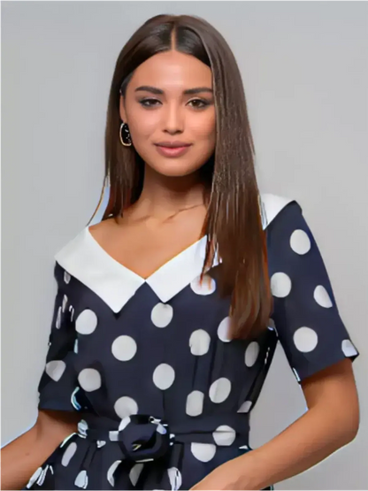 Model wearing a Nautical Charm Midi Dress with polka dots and white collar, perfect for summer events and weddings.