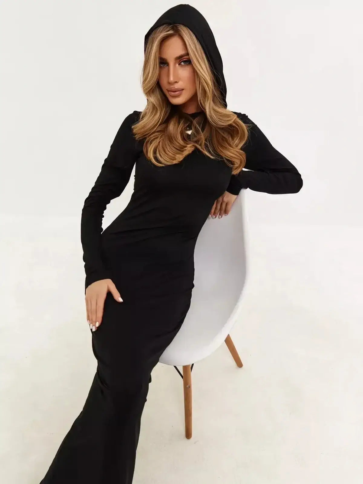 Stylish woman in a black hooded maxi dress, showcasing minimalism and urban elegance.