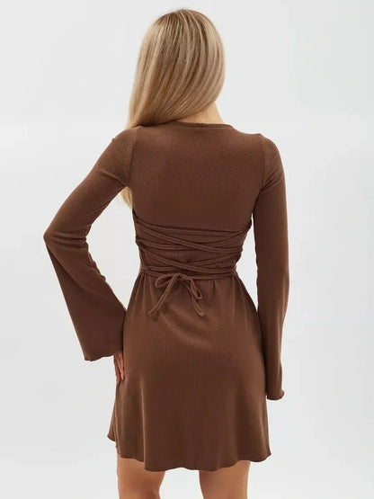 View of the Cocoa Tie Mini Dress showcasing back lace detail and flared sleeves in rich chocolate color.