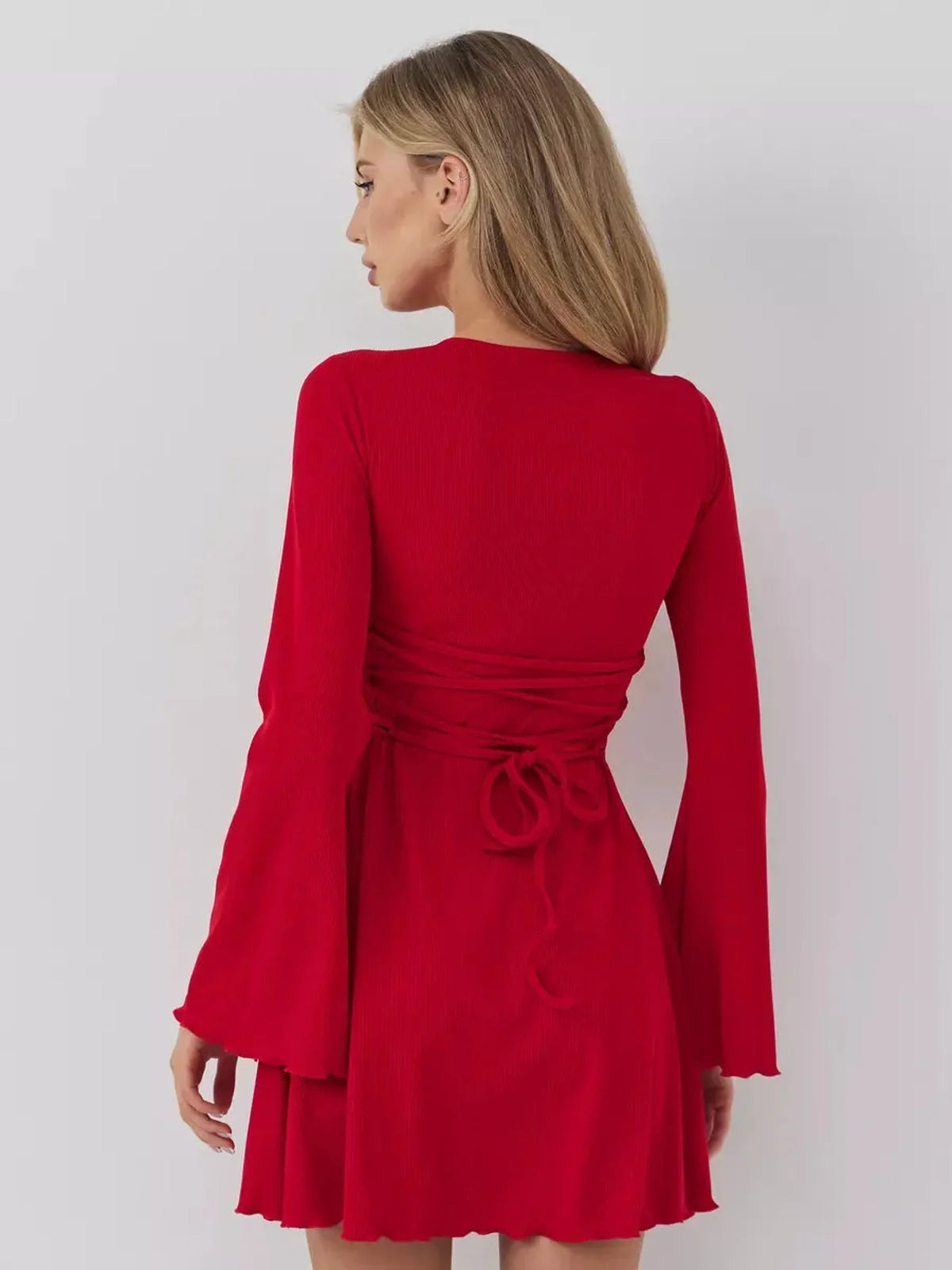 Back view of a stylish red mini dress with long bell sleeves and a tied waist, perfect for summer or formal occasions.