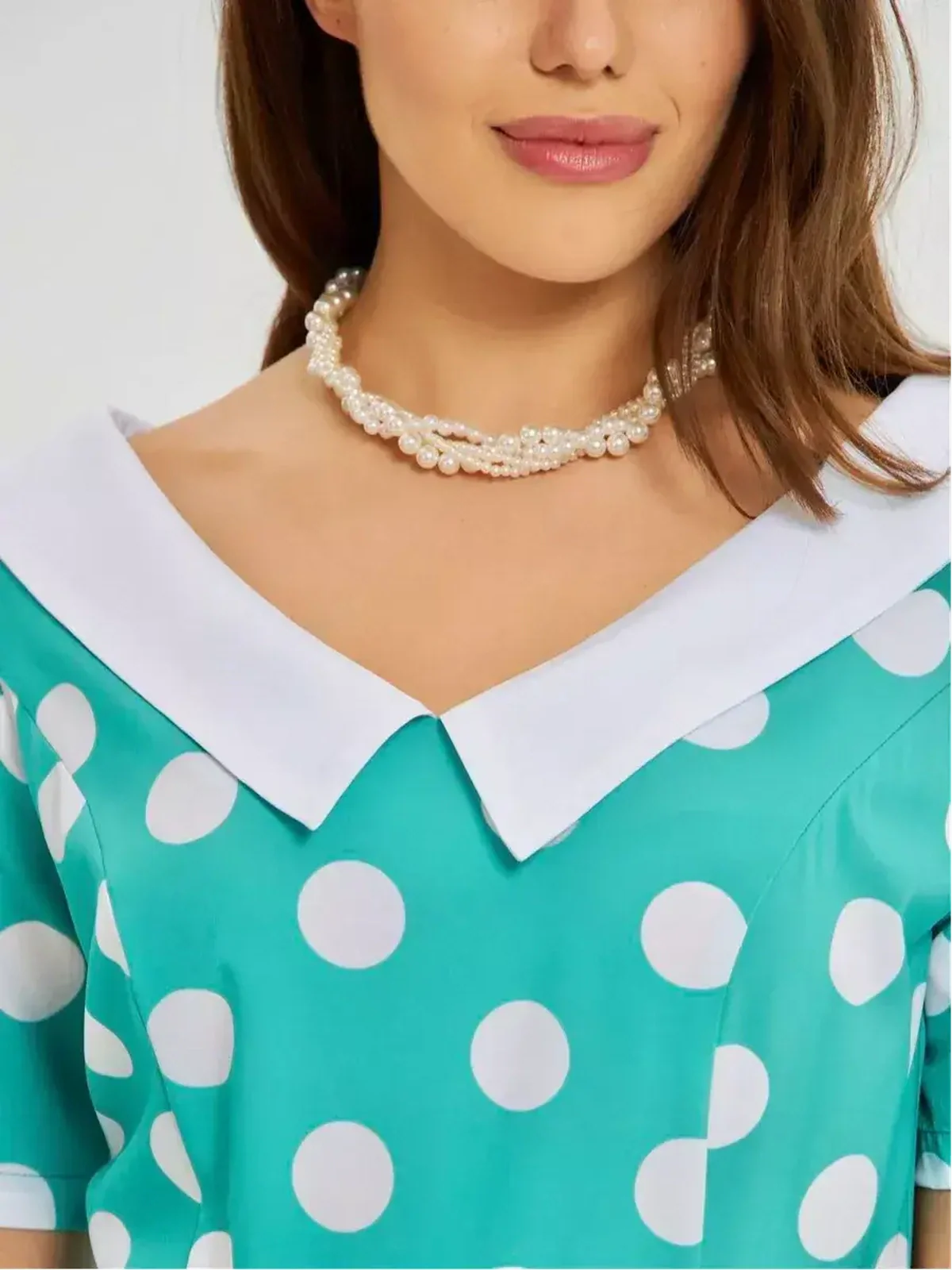 Close-up of a woman wearing the Polka Grace Midi Dress with a white collar and pearl necklace, showcasing retro charm.