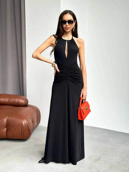 Elegant black maxi dress with ruched halter design, featuring a front slit and stylish accessories for women's formalwear.