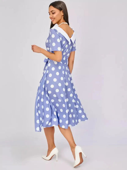Sky-blue midi dress with white polka dots, flattering fit-and-flare silhouette, and a crisp contrast collar.