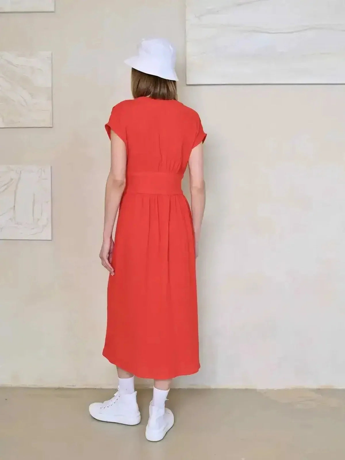 Back view of a woman wearing a red Flare Muse Midi Dress, perfect for summer or wedding guest events.