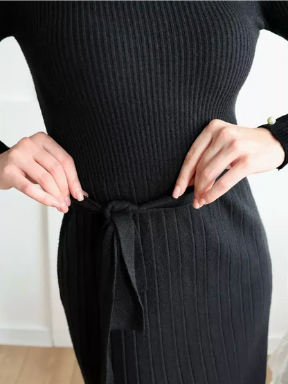 Close-up of hands tying the waist belt of the black ribbed Midnight Grace Midi Dress, showcasing elegant styling.