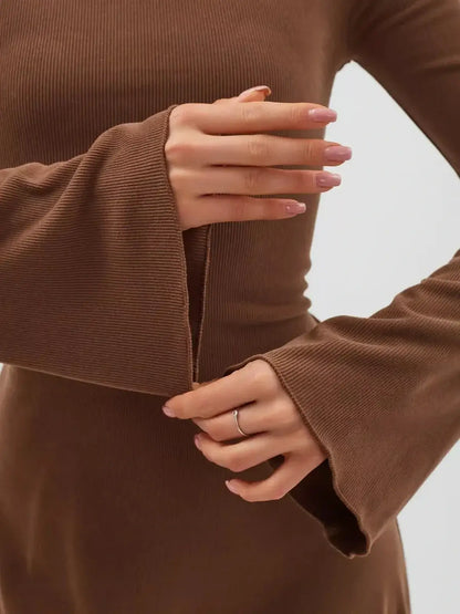 Close-up of hands adjusting the flared sleeves of a Cocoa Tie Mini Dress in rich chocolate color.