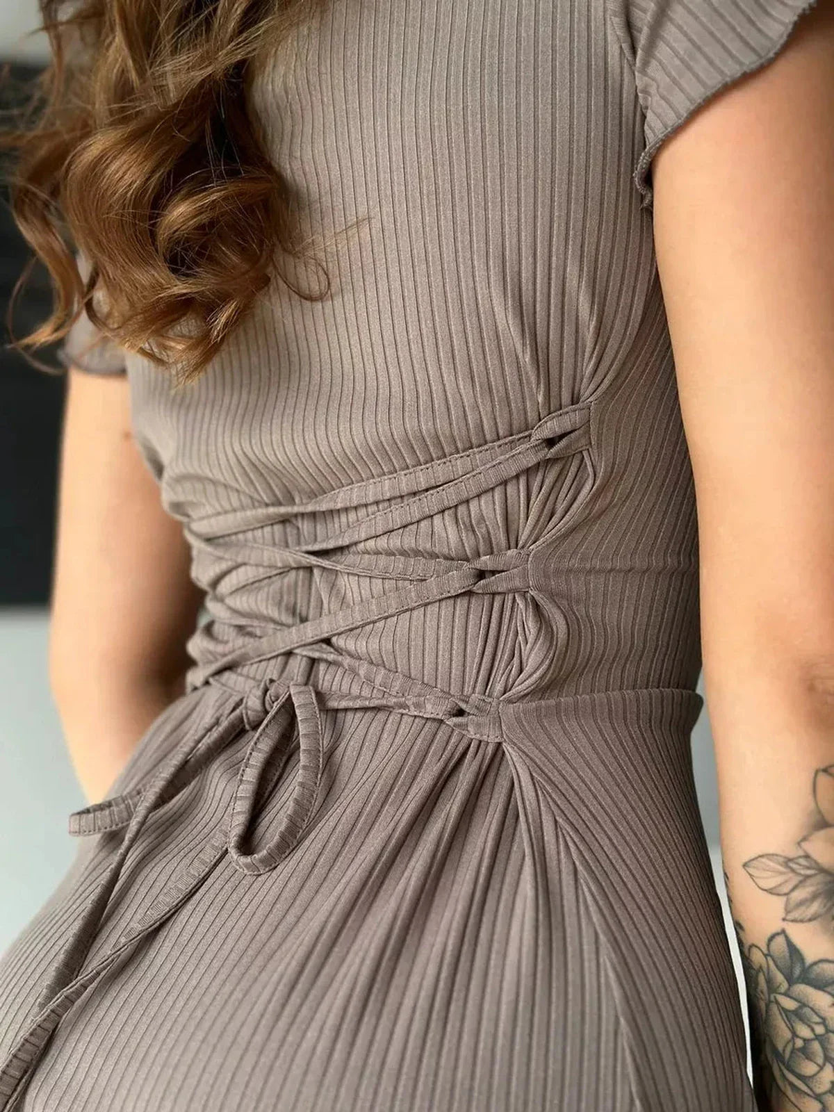 Back view of a ribbed midi dress showcasing lace-up waist detail, perfect for summer or as a wedding guest dress.