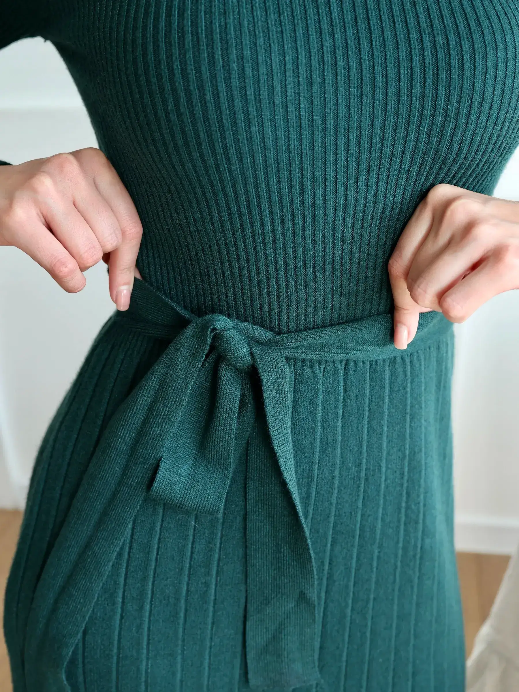 Close-up of the ribbed knit waist tie on the elegant Emerald Grace Midi Dress in emerald green.