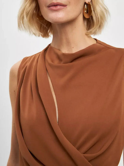 Elegant woman in a warm light brown sculpted drape dress showcasing fluid draping and a refined neckline.