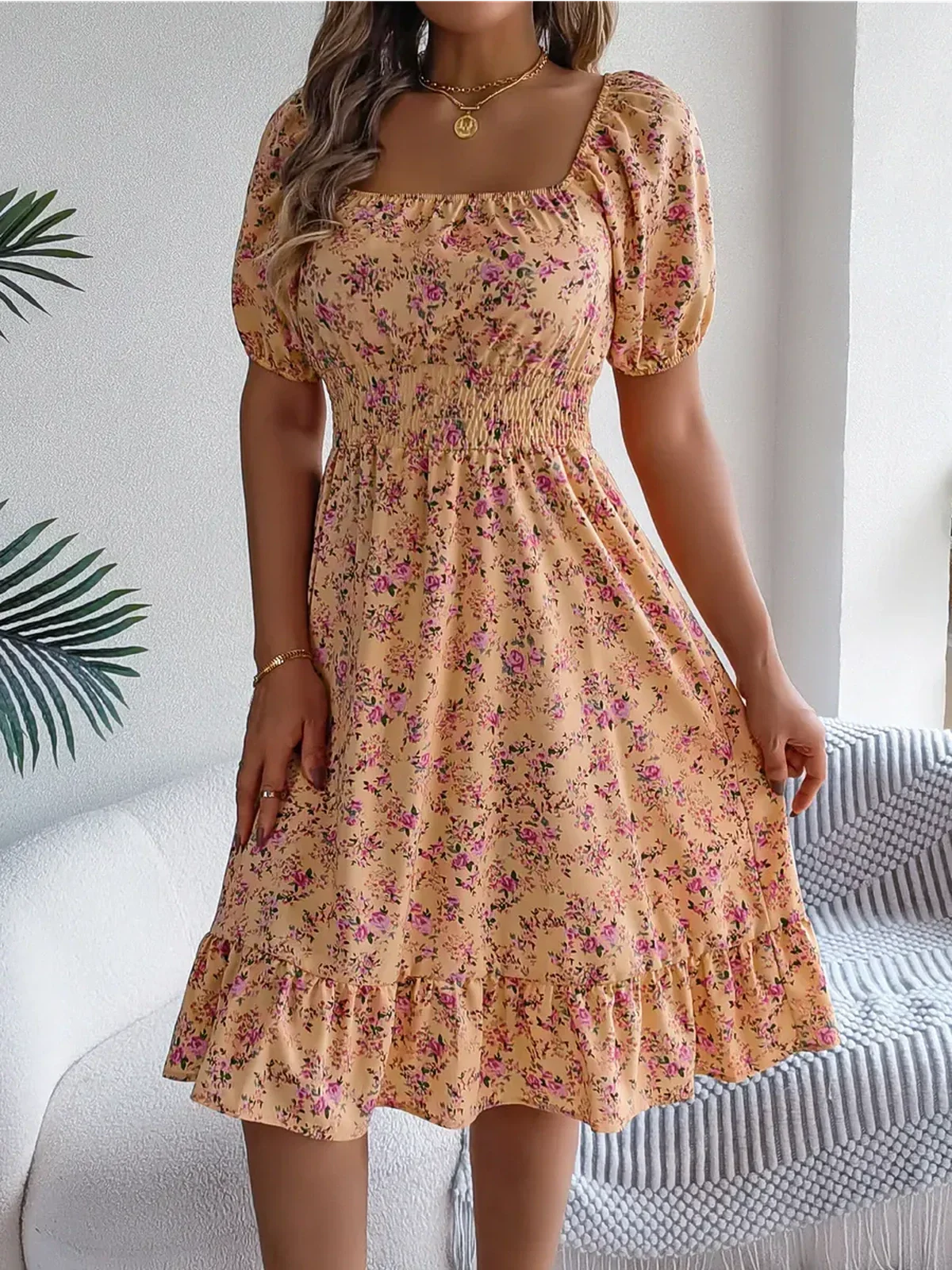 Floral midi dress in marigold with puff sleeves and smocked waist, perfect for summer and weddings.