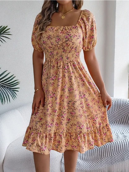 Floral midi dress in marigold with puff sleeves and smocked waist, perfect for summer and weddings.