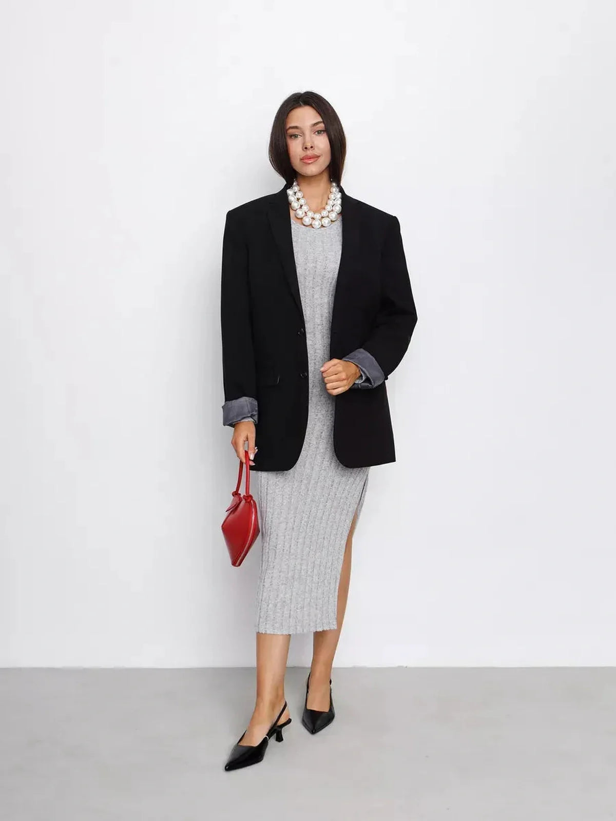 Model showcasing a Soft Curve Midi Dress styled with an oversized blazer and red handbag, perfect for chic women's fashion.