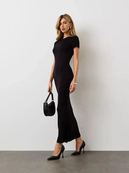Model showcasing the Noir Curve Maxi Dress, a sculpted black dress perfect for formal events and summer occasions.