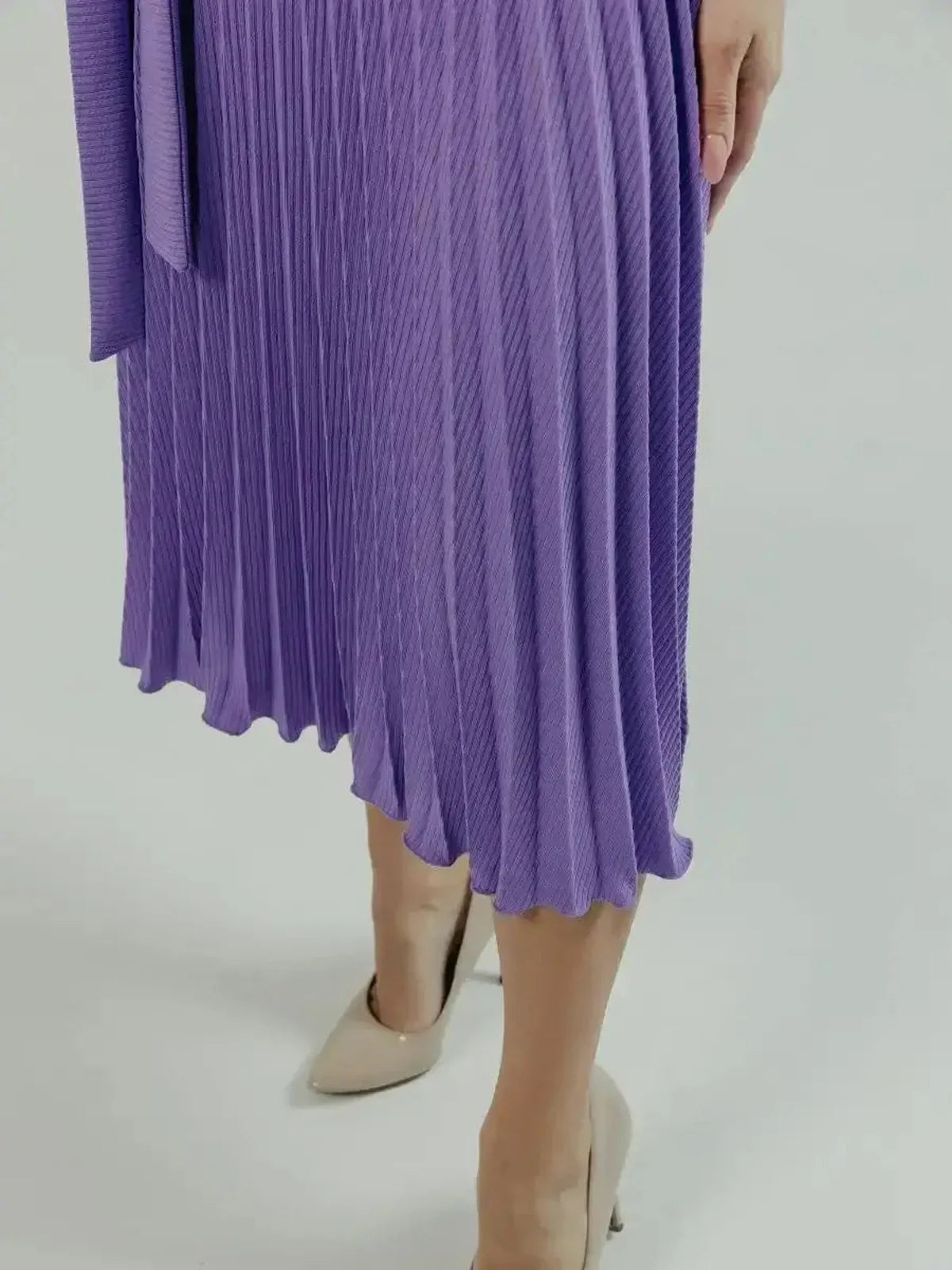 Close-up of the pleated skirt of the Serena Midi Dress in violet, showcasing elegant texture and movement.