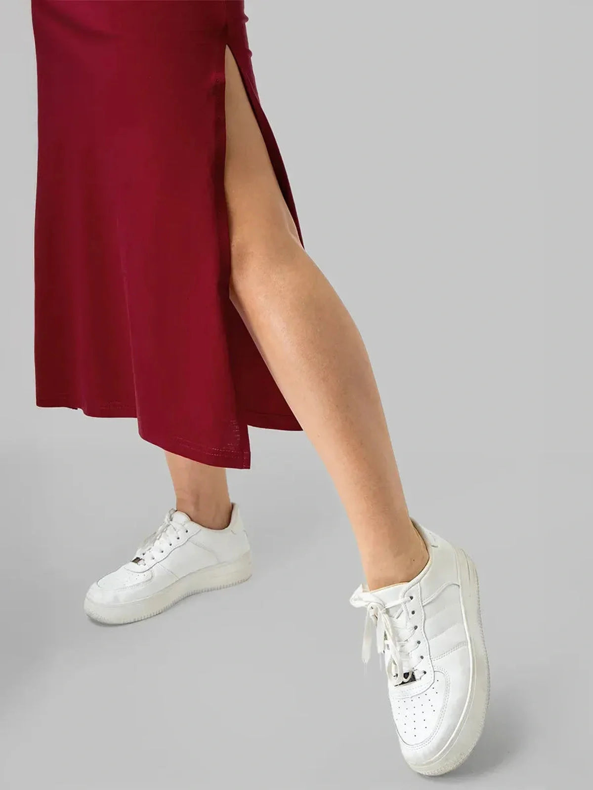 Burgundy essential cotton midi dress with a stylish side slit paired with white sneakers for a modern look.