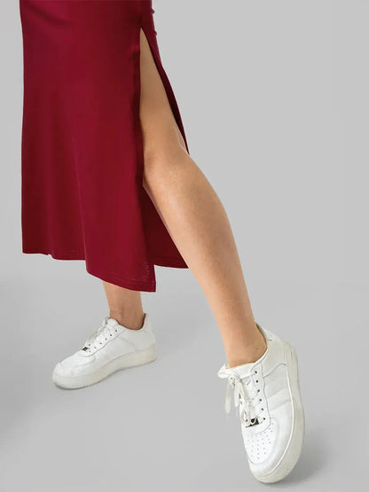 Burgundy essential cotton midi dress with a stylish side slit paired with white sneakers for a modern look.