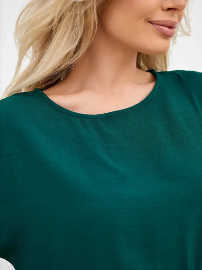 Close-up of a woman wearing a soft emerald green fabric, ideal for summer dresses and versatile casual wear.