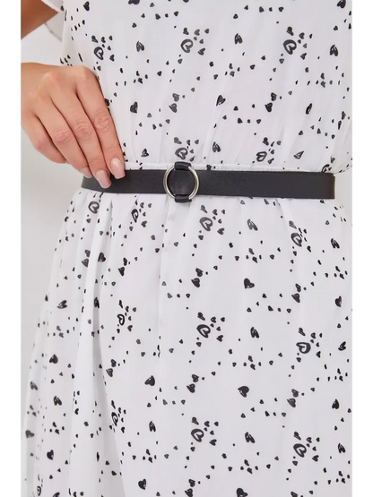 Close-up of a black belt cinching the waist of a white mini dress with an abstract print.