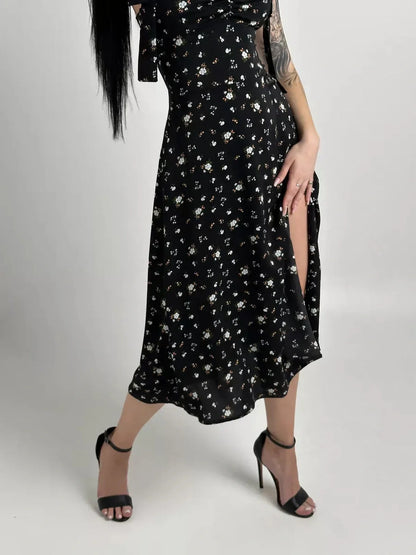 Elegant black floral Elysian Midi Dress featuring romantic bows and a stylish slit, perfect for summer occasions.