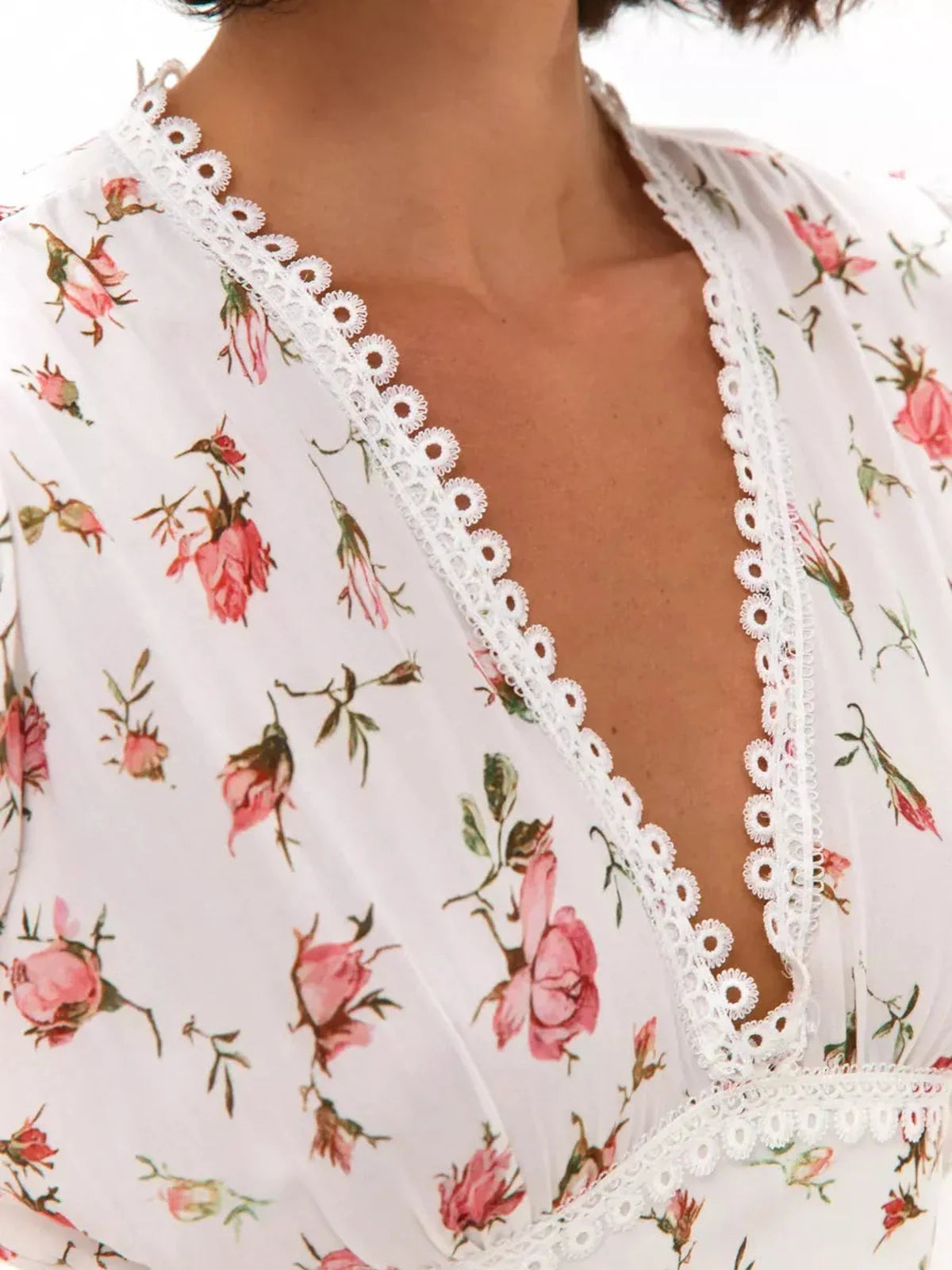 Close-up of Rose Whimsy Mini Dress showcasing delicate floral print and lace trim, perfect for summer weddings and elegant outings.