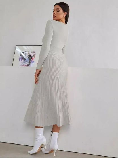 Woman in a sculpted grey midi dress, showcasing ribbed texture and pleated skirt, perfect for wedding guest or formal occasions.
