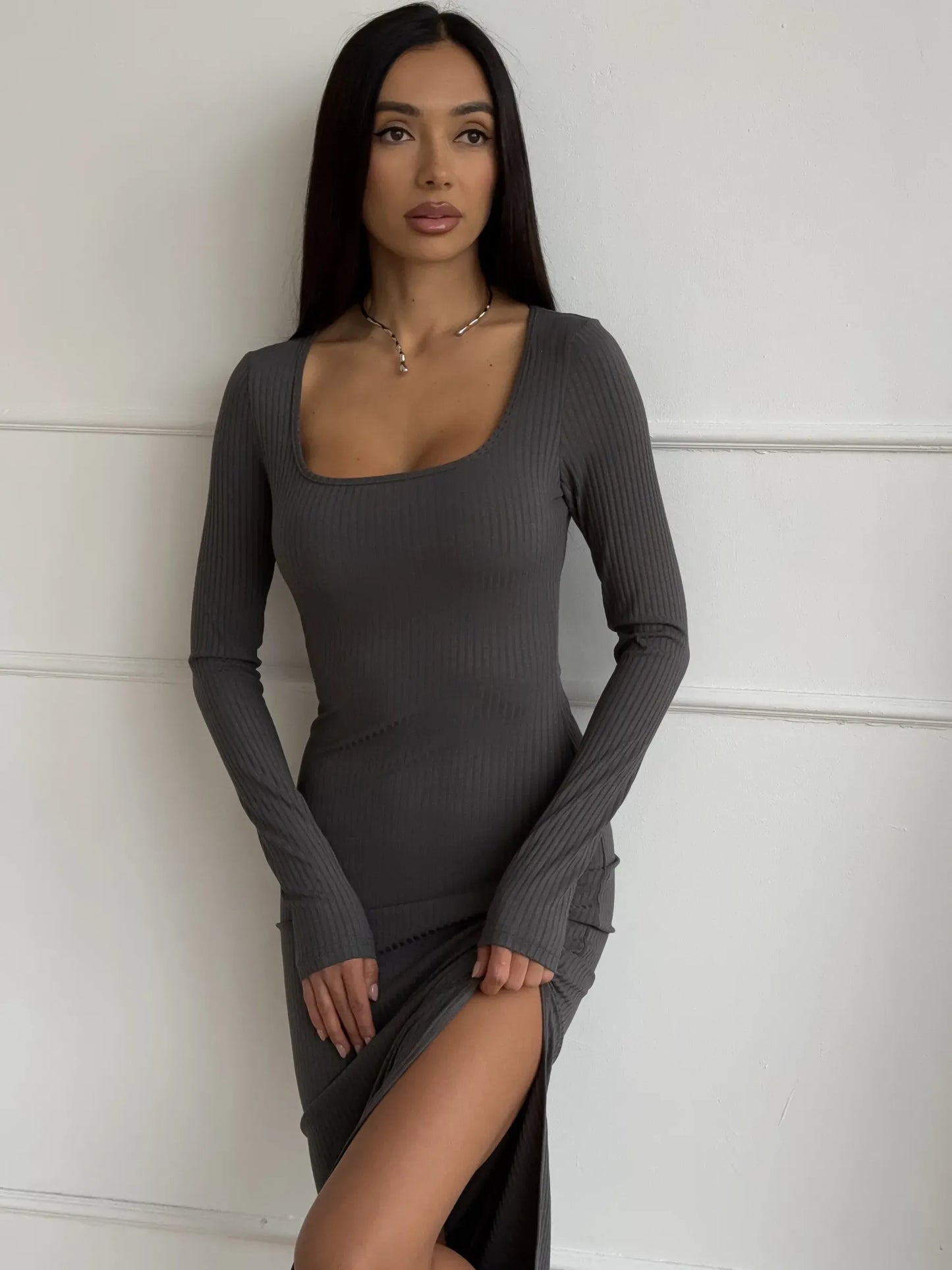 Model wearing a Sculpted Grace Midi Dress featuring a ribbed silhouette and thigh-high slit, perfect for elegant occasions.