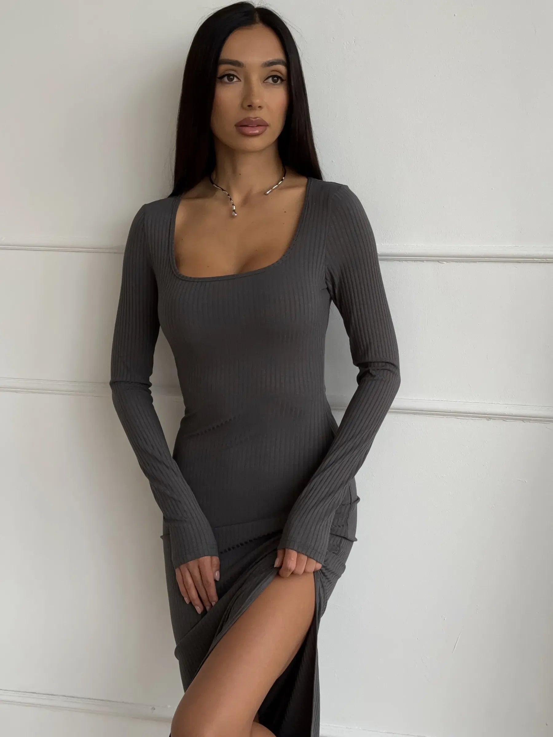 Model wearing a Sculpted Grace Midi Dress featuring a ribbed silhouette and thigh-high slit, perfect for elegant occasions.
