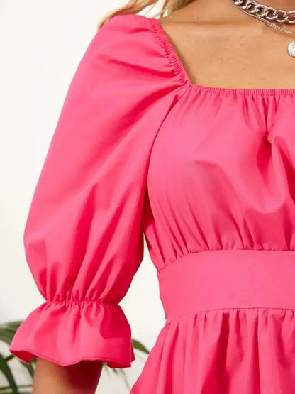 Close-up of the pink Candy Bow mini dress showcasing its puff sleeves and elasticated neckline, perfect for summer occasions.