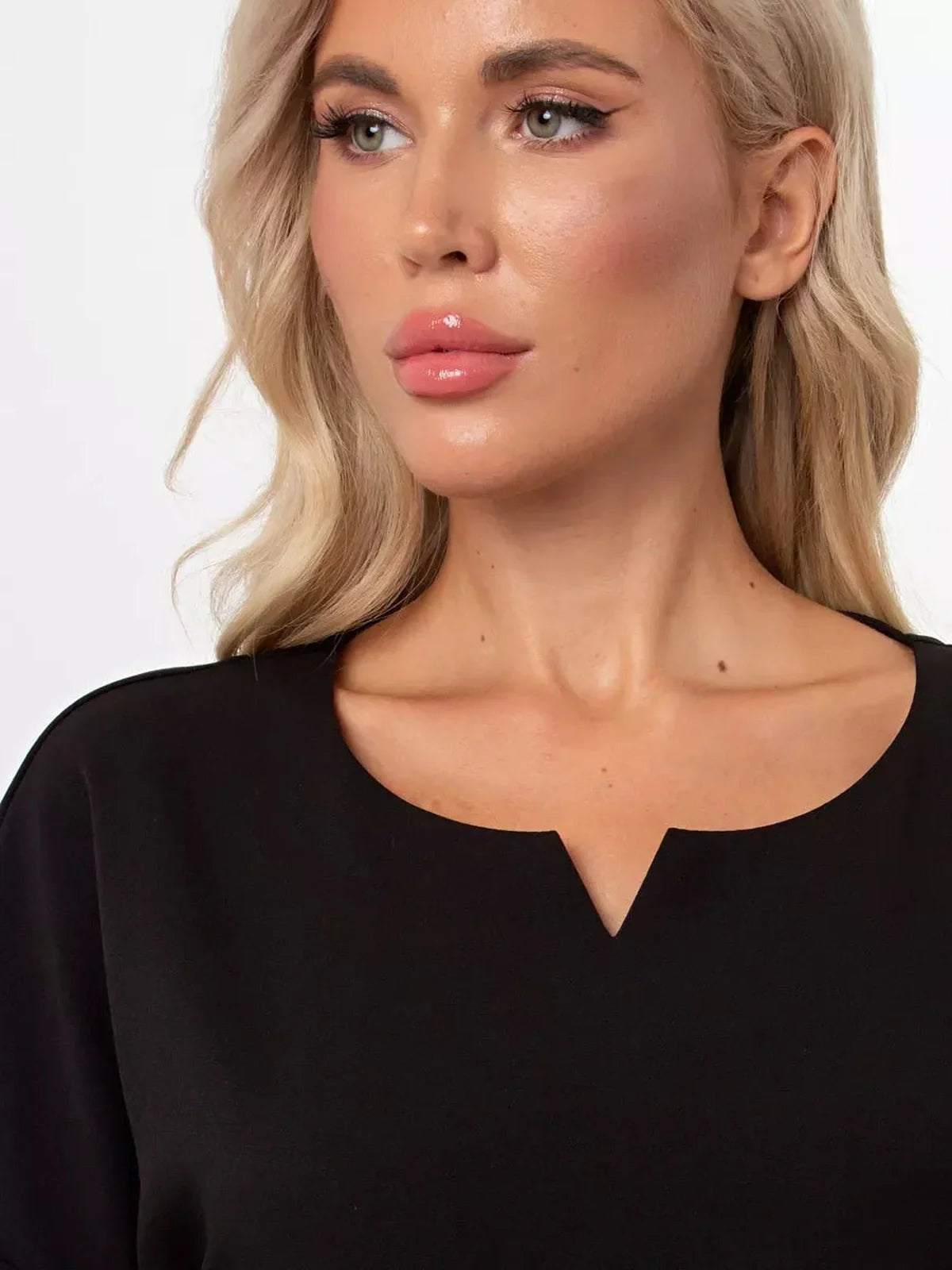 Close-up of a model showcasing the subtle rounded neckline of the Modern Grace black mini dress.