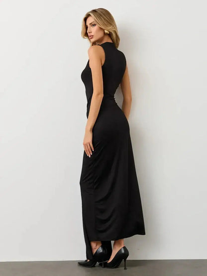 Elegant woman in a sleeveless black maxi dress showcasing a sculpted silhouette and dramatic draping.