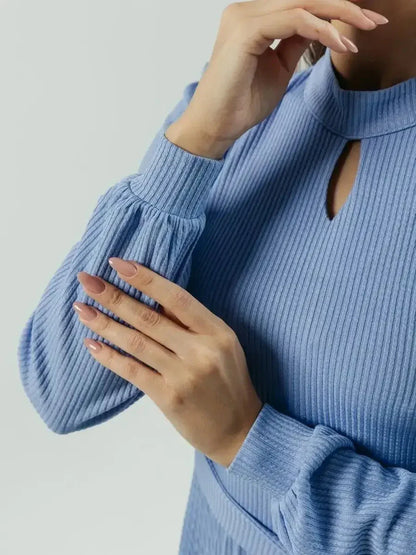 Close-up of elegant powder blue midi dress, highlighting keyhole neckline and fitted long sleeves.