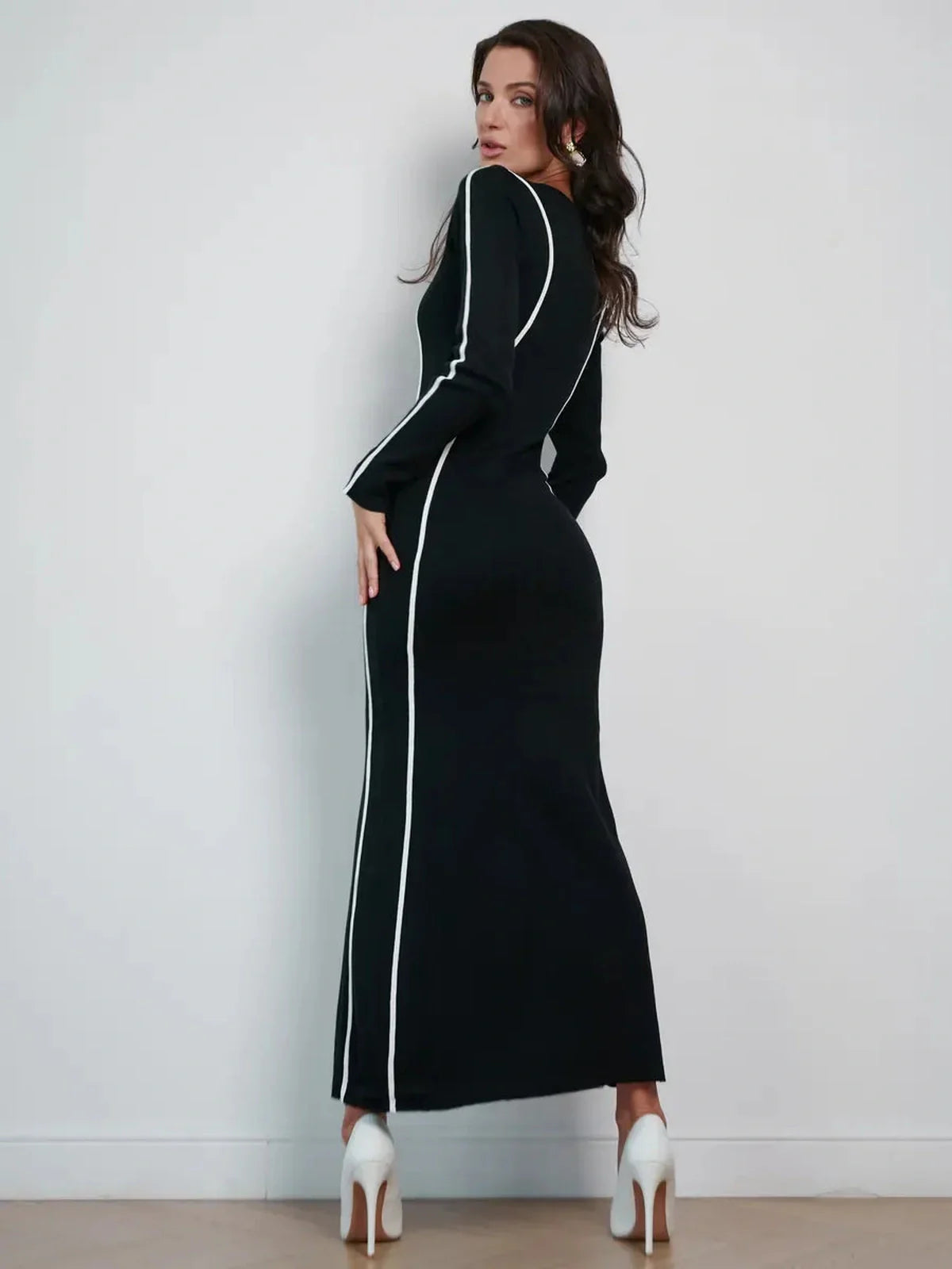 Elegant black maxi dress with contrast piping, highlighting a sculpting silhouette and perfect for formal occasions.
