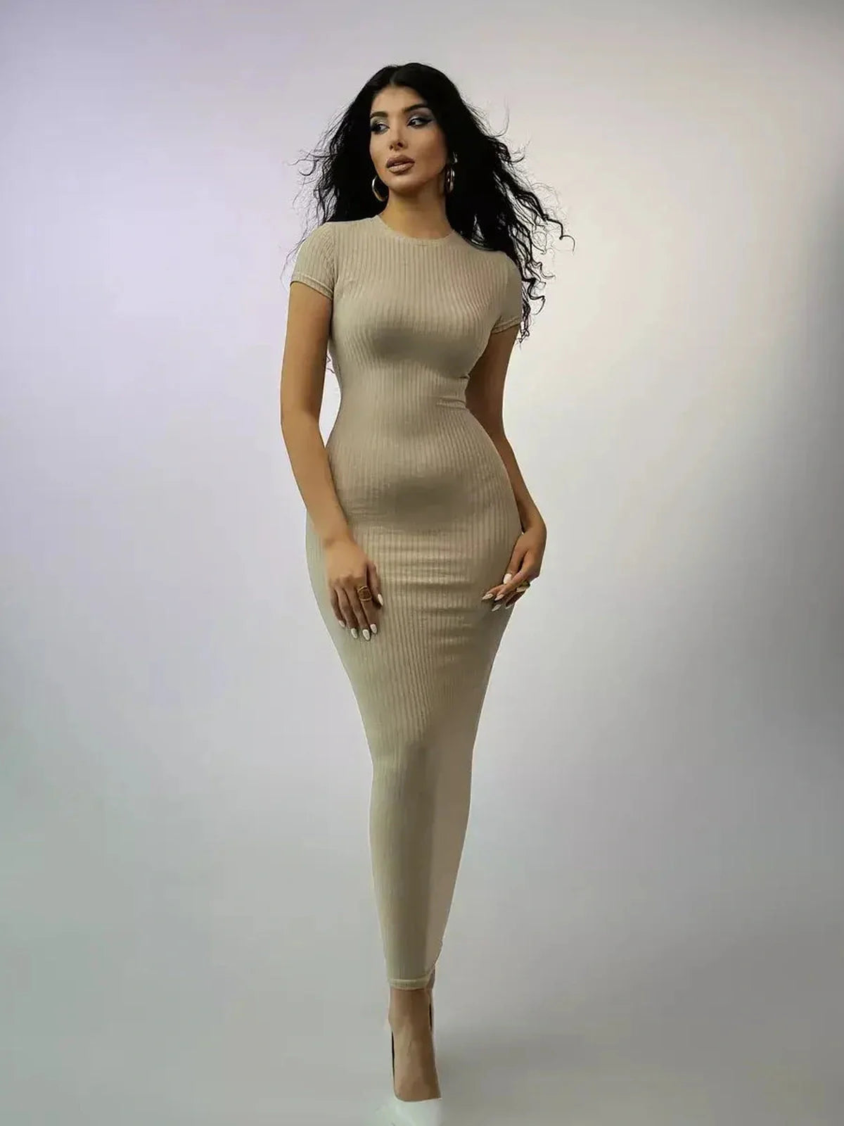 Sculpted fit beige maxi dress with ribbed texture, short sleeves, and minimalist neckline, perfect for summer or formal occasions.