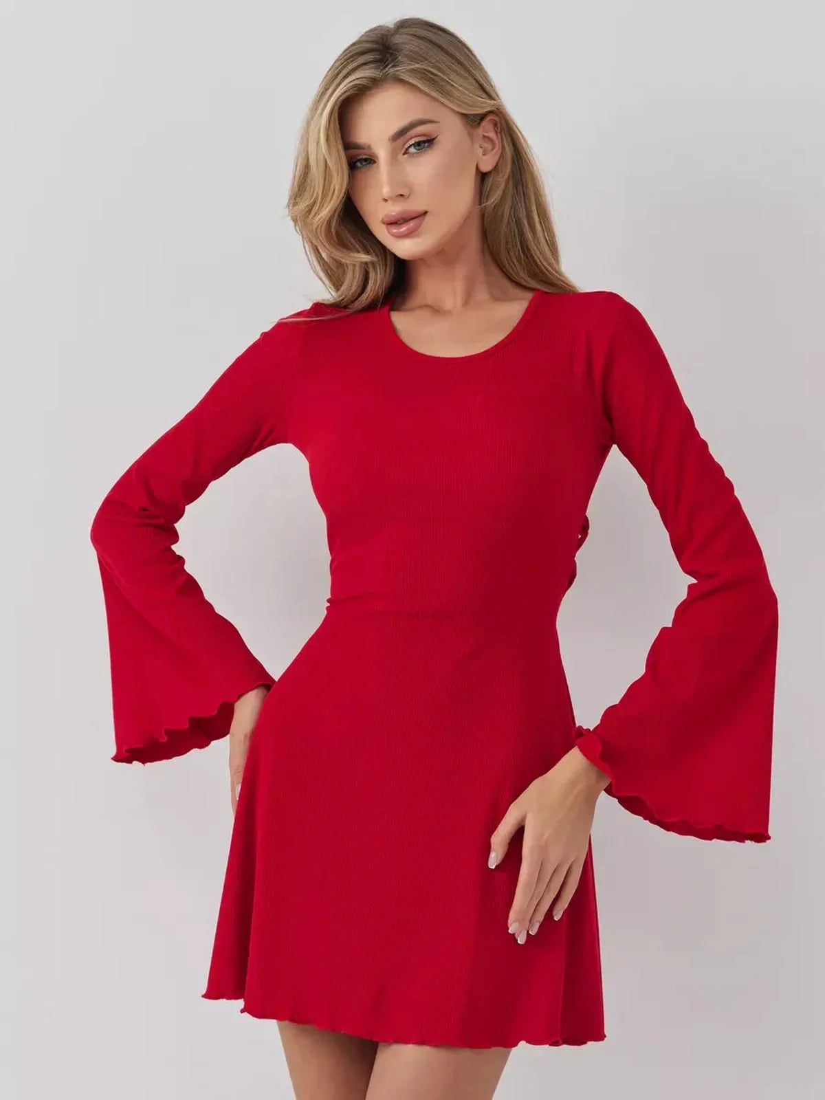 Woman in a stunning red mini dress with flared sleeves, perfect for weddings and special occasions.