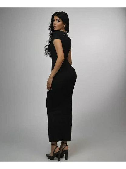 Stylish woman wearing an obsidian maxi dress, showcasing a sculpted silhouette and modern design against a plain background.