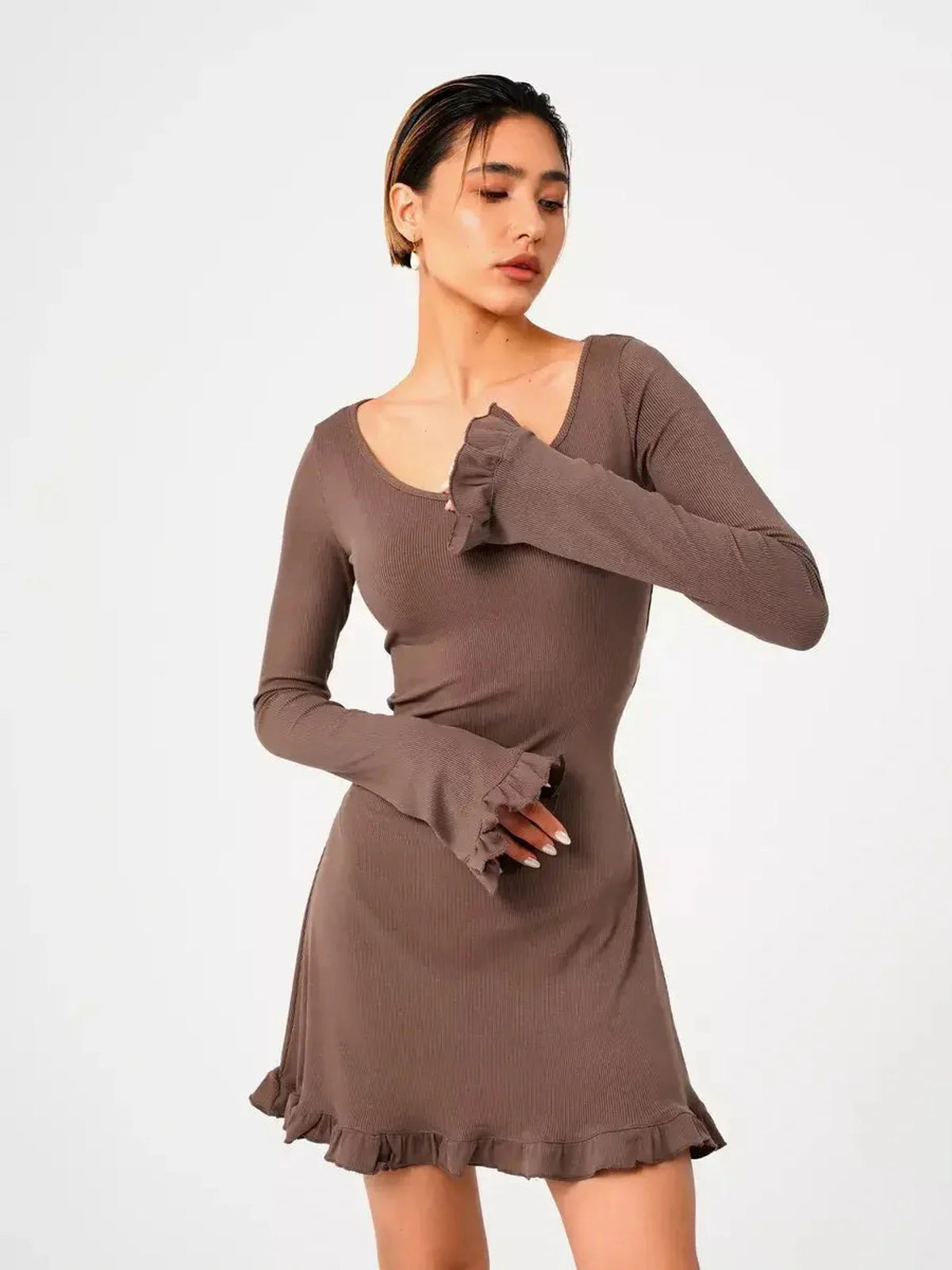 Model showcasing the Mocha Flare ribbed knit mini dress with flared cuffs and ruffled hem, perfect for summer and special occasions.