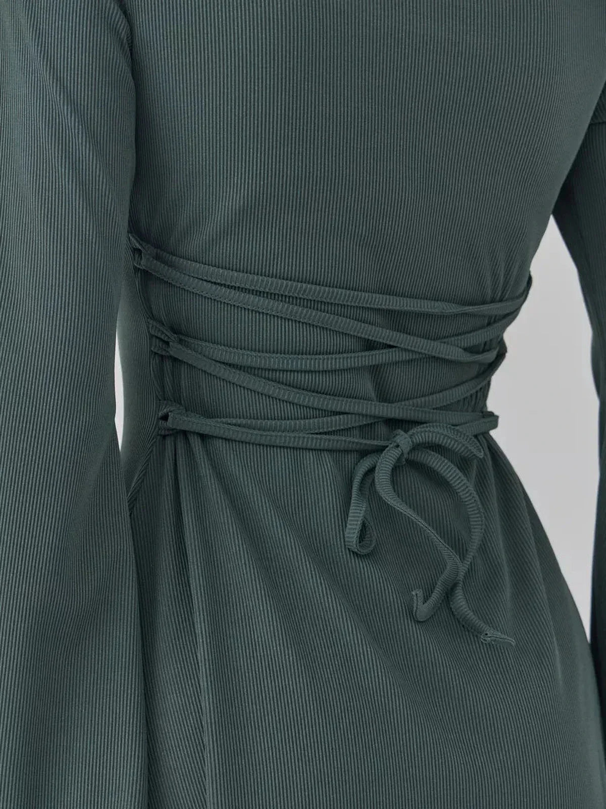 Close-up of the back lace-up detail on the Sculpt Flare dark olive mini dress, showcasing its stylish design and silhouette.