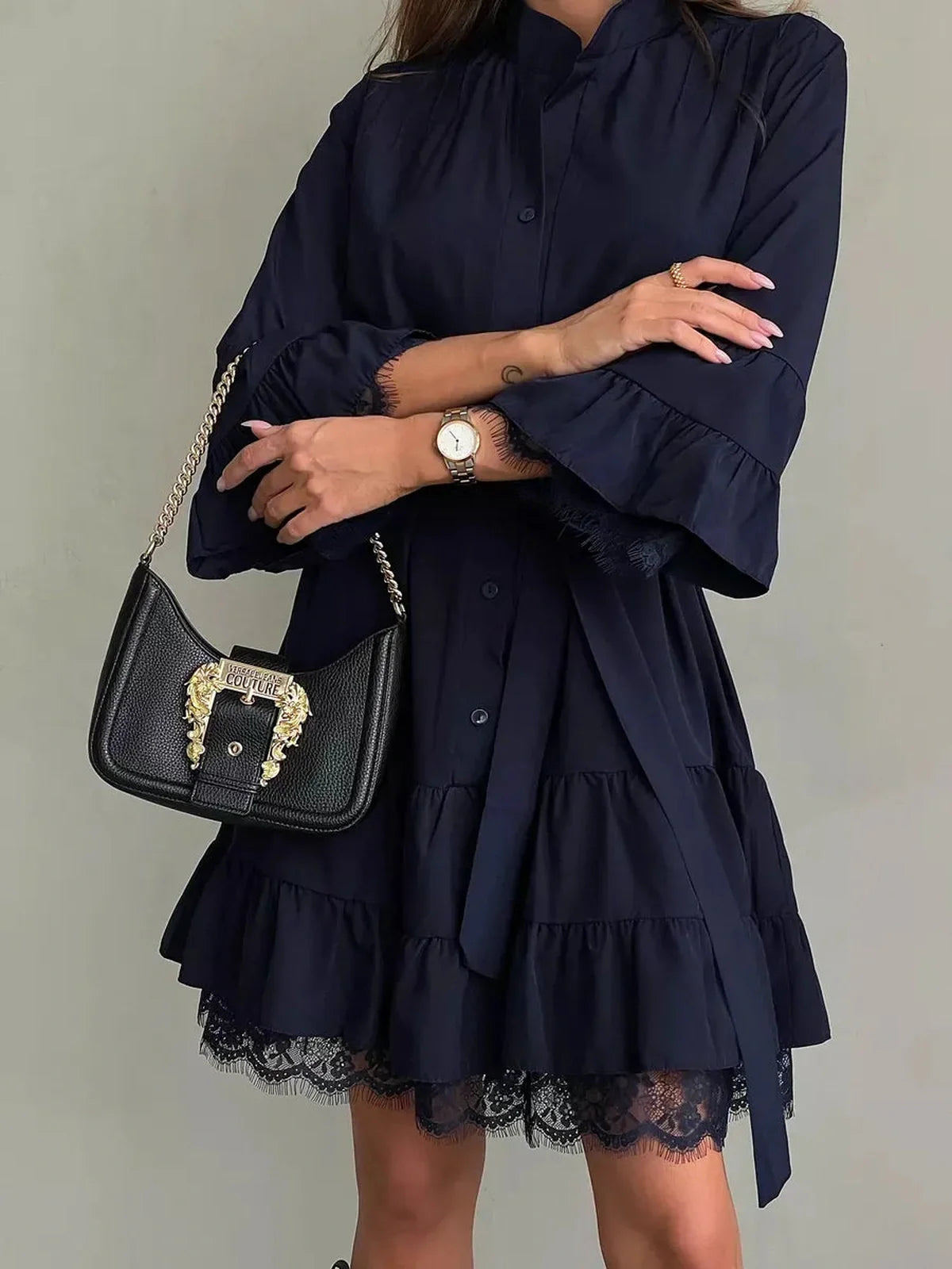 Navy blue lace flare mini dress with ruffle details, styled with a chic handbag and watch, perfect for summer and special occasions.