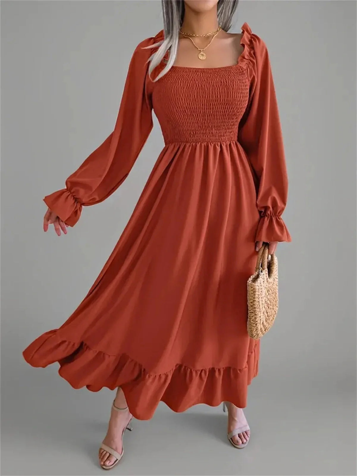 Rust Charm Midi Dress featuring a smocked bodice, flouncy hem, and long sleeves, perfect for weddings or casual outings.