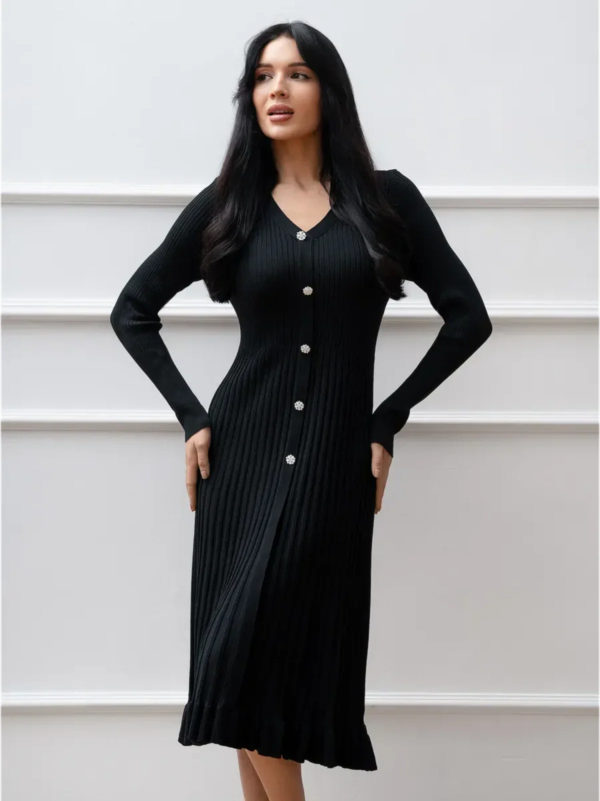 Elegant black midi dress with ribbed knit, crystal buttons, and ruffled hem, perfect for formal or casual occasions.