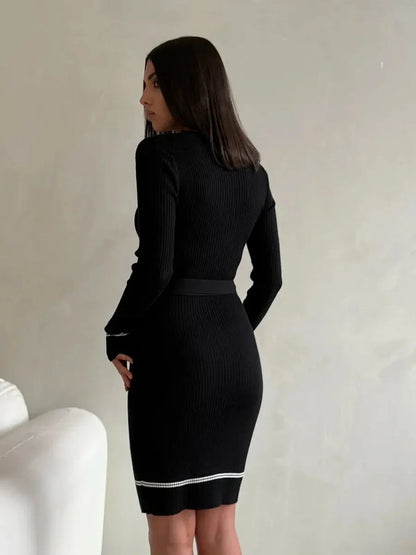 Elegant black ribbed knit midi dress with long sleeves and a fitted silhouette.