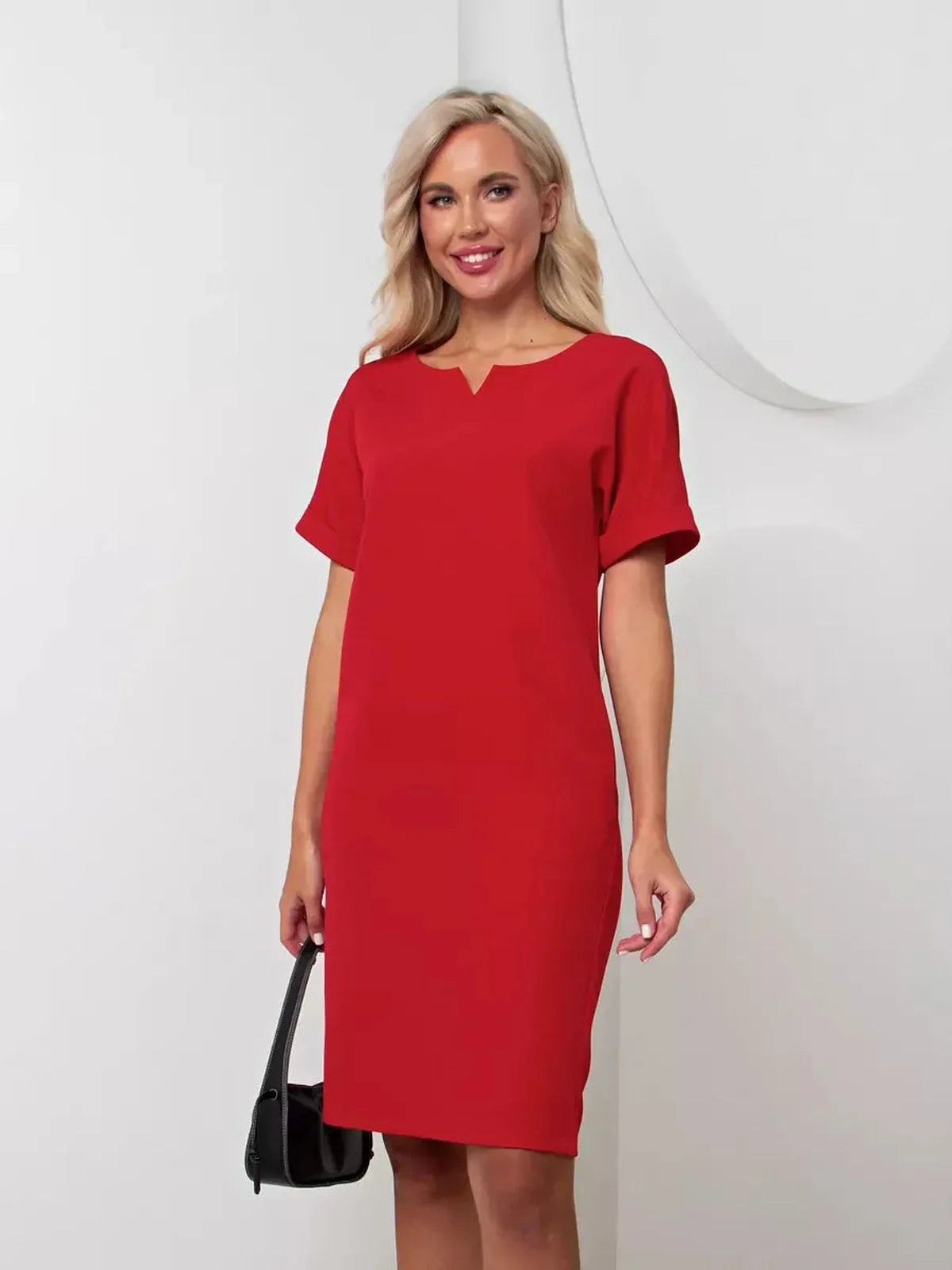 Woman wearing a sleek red mini dress with a notch neckline, perfect for weddings and formal events.