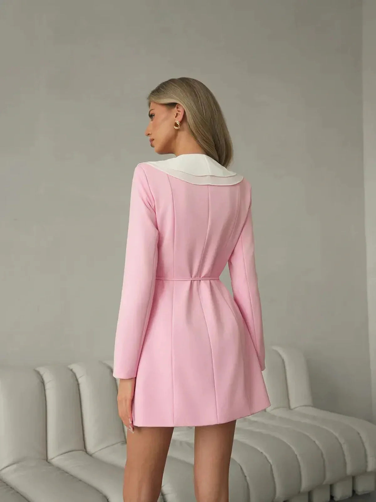 Back view of a stylish blush pink mini dress with a white ruffle collar, perfect for wedding guest or cocktail events.