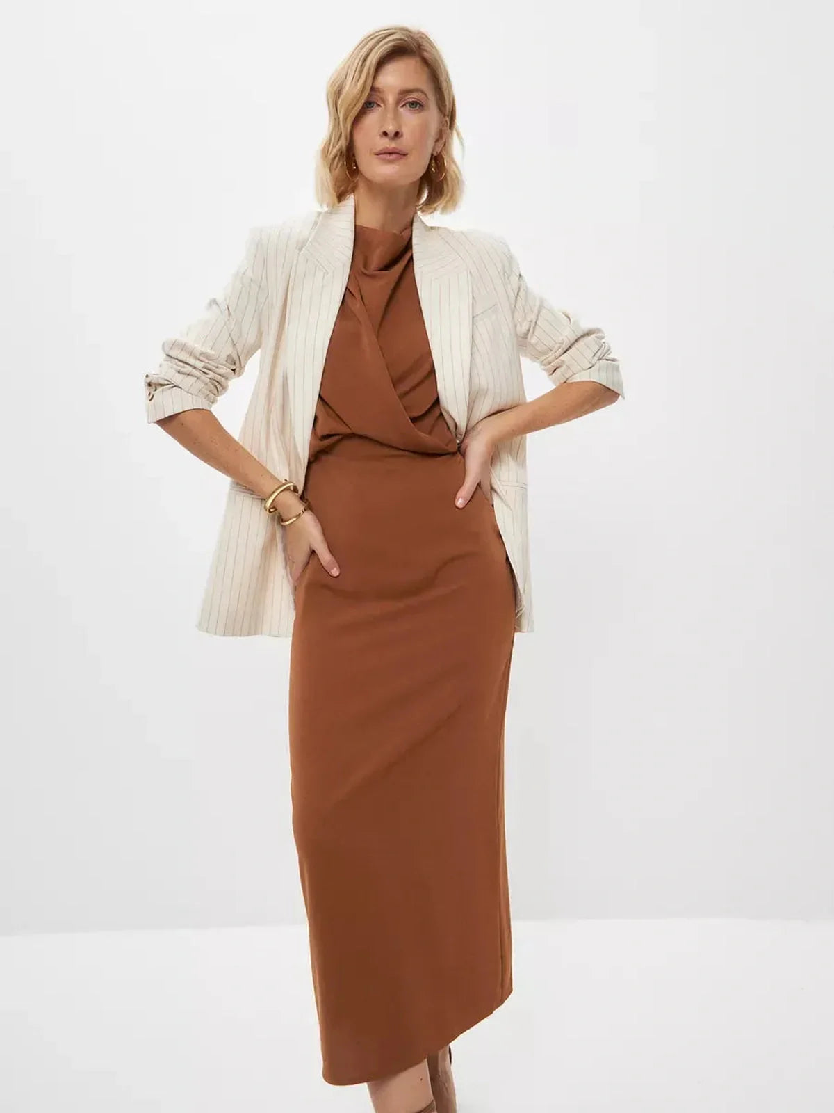 Sculpted Drape Maxi Dress in light brown worn with a striped blazer, perfect for formal occasions and elevating women's wardrobe.