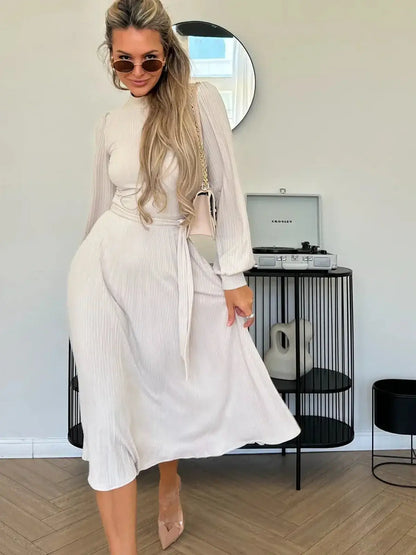 Model wearing an Ivory Whisper Midi Dress with ribbed texture and flowing pleated design, styled for a chic and elegant look.